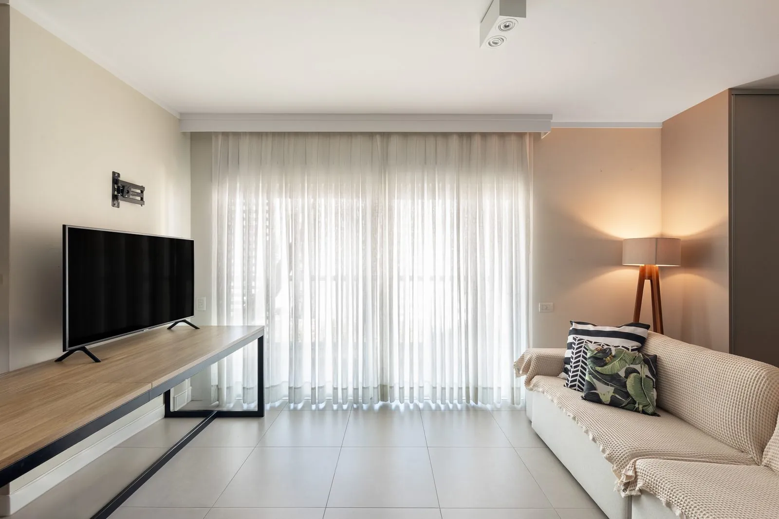 Sala de estar com cortinas e TV do Estúdio Central
