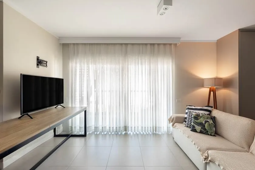 Sala de estar com cortinas e TV do Estúdio Central