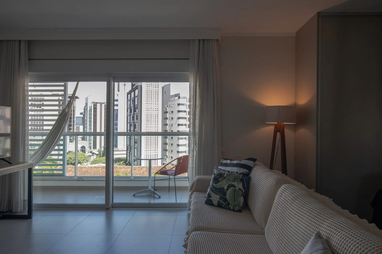Sala de estar do Estúdio Central com vista noturna para o Centro de Florianópolis